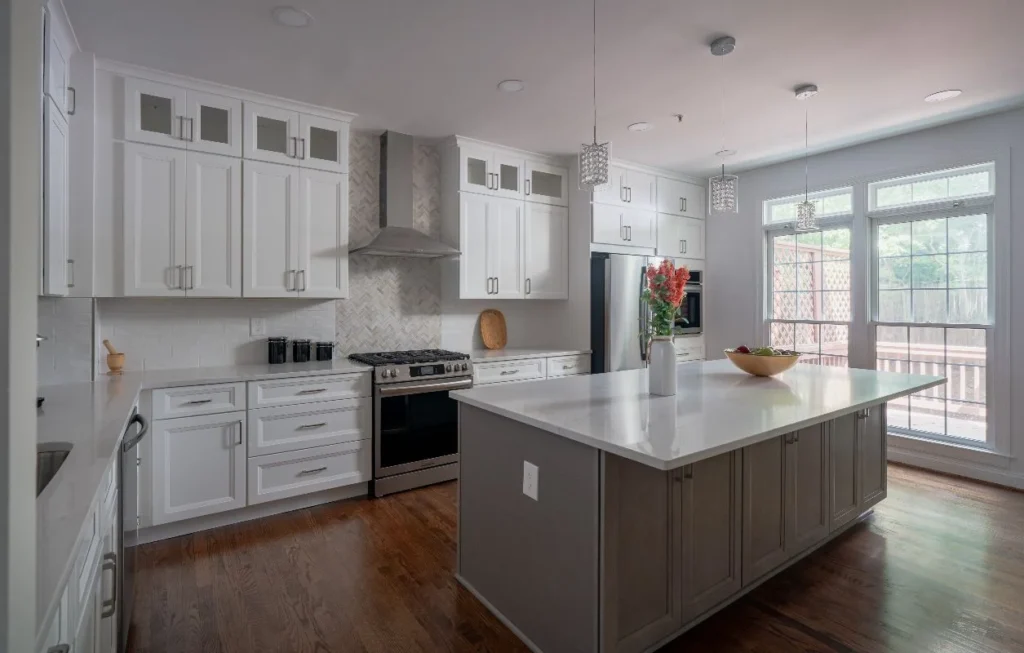 Kitchen with contrasting island, white cabinets, and large windows