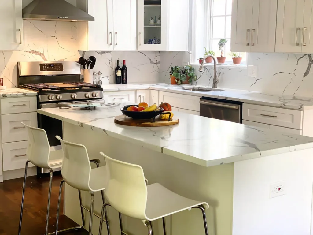 Kitchen island with seating and quartz countertop overhang in modern white kitchen design