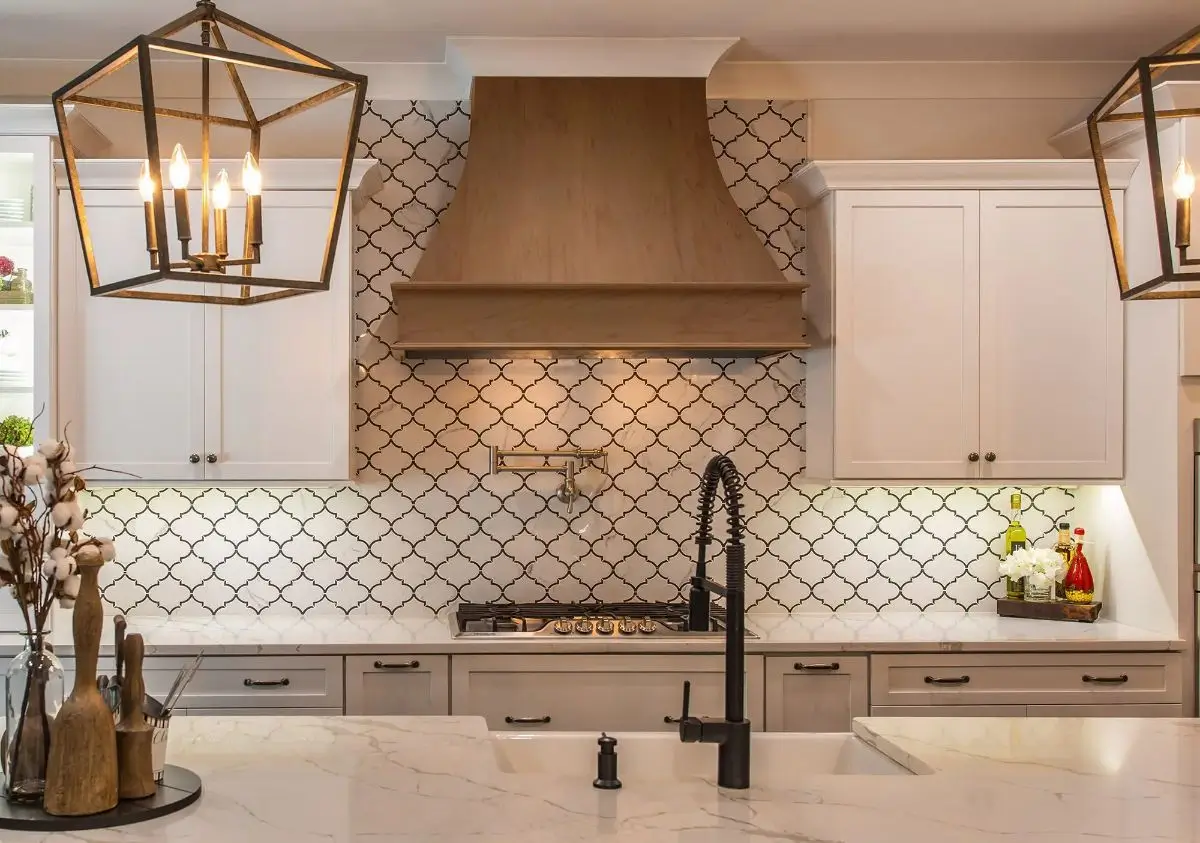 Custom kitchen with wood range hood, patterned backsplash, and pot filler