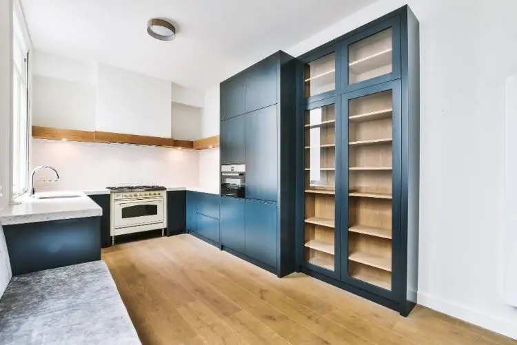 Modern kitchen with floor-to-ceiling built-in cabinetry and glass storage unit