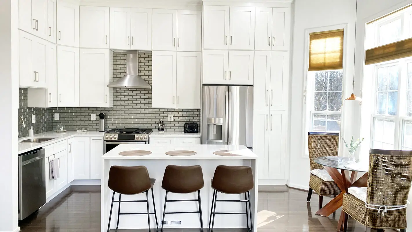 Modern white shaker kitchen with quartz island and stainless steel appliances