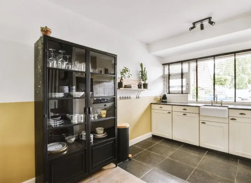 Small kitchen with freestanding glass cabinet and compact storage design