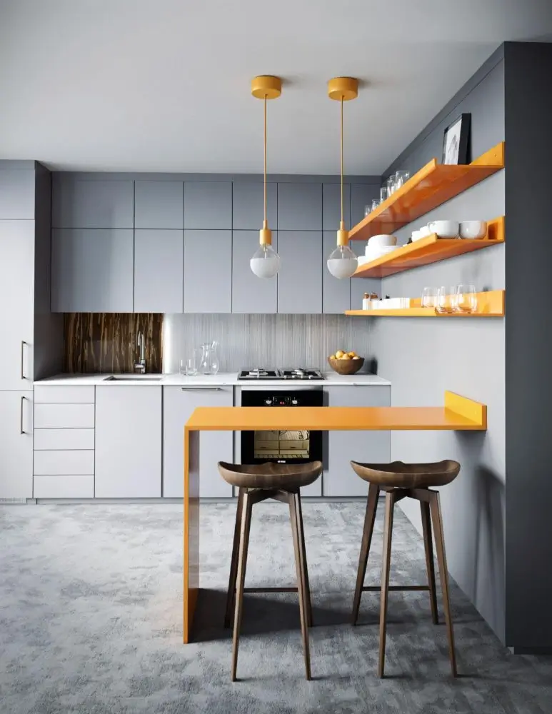 Small modern kitchen with gray cabinets, orange accent shelves, and compact peninsula seating