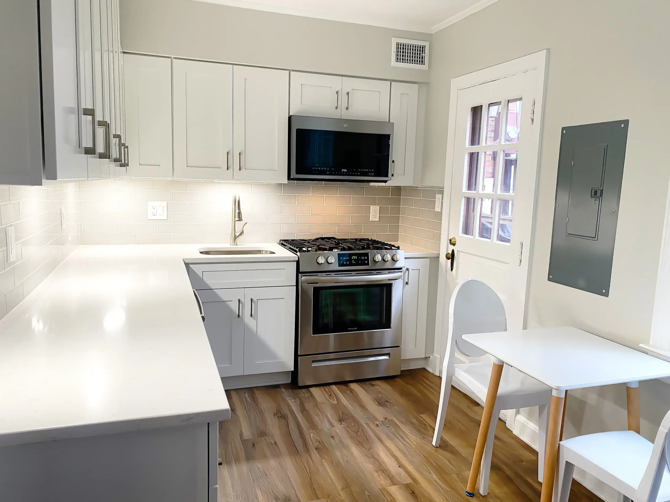 Compact light gray Shaker kitchen with white quartz countertops and subway tile backsplash, a stock-cabinet remodel in a Northern Virginia townhome