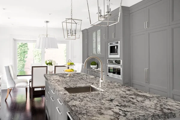 Gray shaker kitchen with granite island and built-in ovens