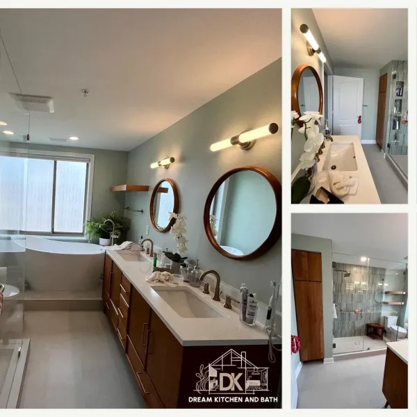 Mid-range bathroom remodel in Northern Virginia featuring large-format gray porcelain tile shower with twin recessed niches, frameless glass enclosure, brushed nickel handheld showerhead, and quartz-top vanity with navy blue shaker cabinetry.