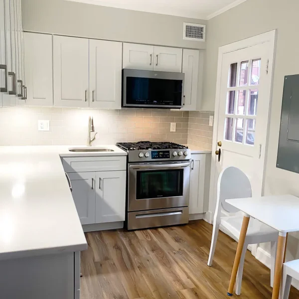 Modern kitchen remodel with quartz countertops, gas range, and dining area