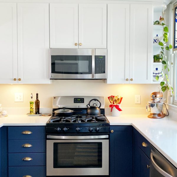 Symmetrical kitchen design with blue cabinets, quartz countertops, and centered cooking area