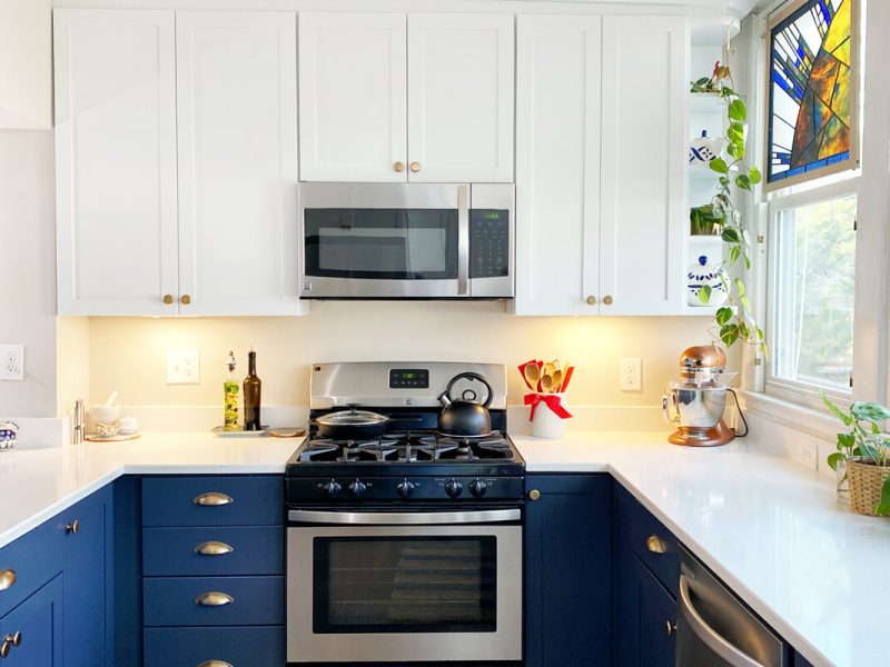 Symmetrical kitchen design with blue cabinets, quartz countertops, and centered cooking area