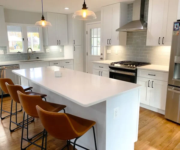 White shaker kitchen with quartz island and bar stools
